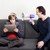 Kind und Vater mit Megaphon sitzen auf der Couch