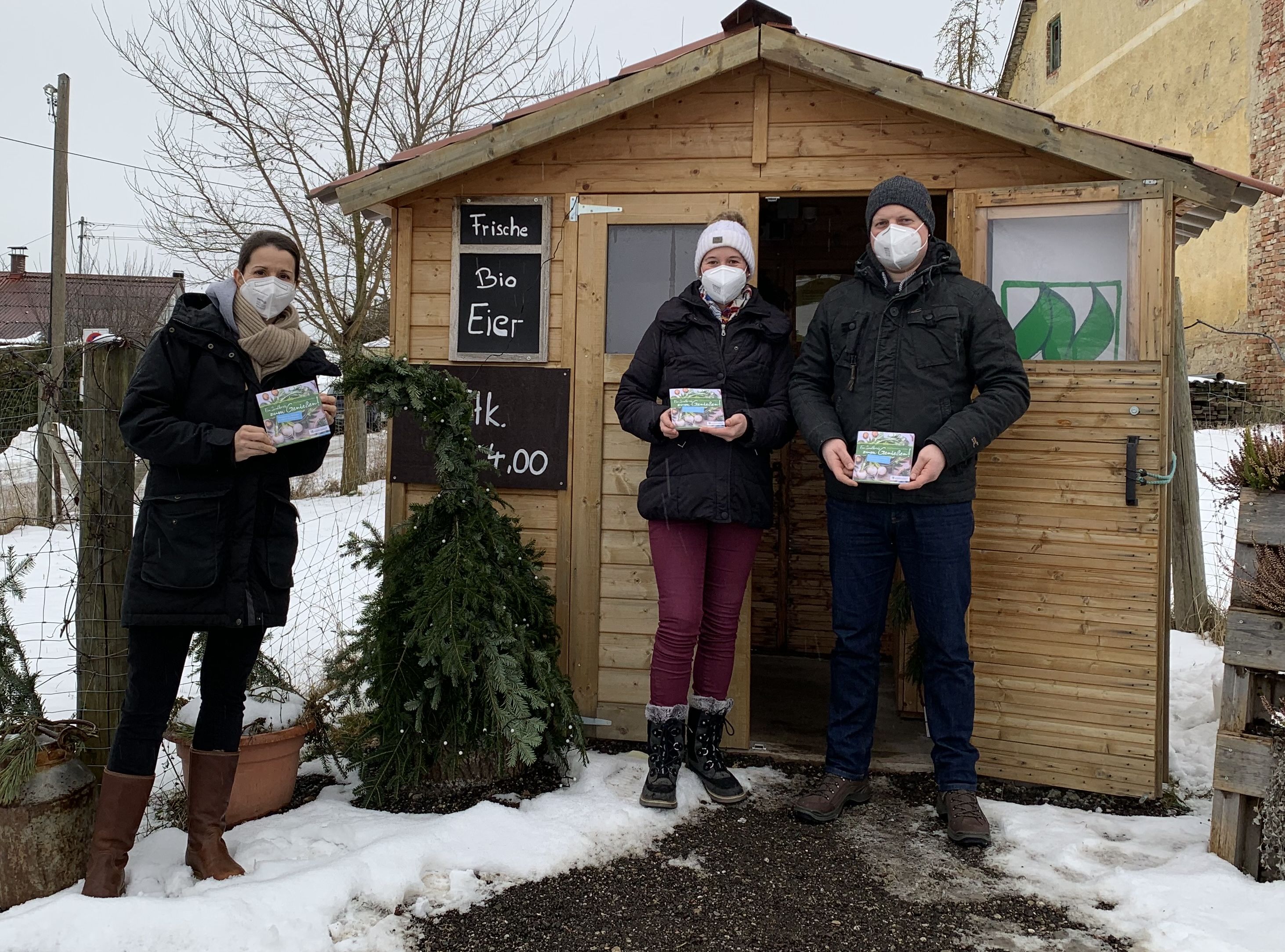 KUS-Projektverantwortliche Britta Lemloh (links) überreicht die ersten Exemplare der neuen Genussbroschüre an Maria und Martin Müller vom Moierhof in Haimpertshofen.