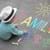 kleines Kind malt auf den Boden Straßenkreide