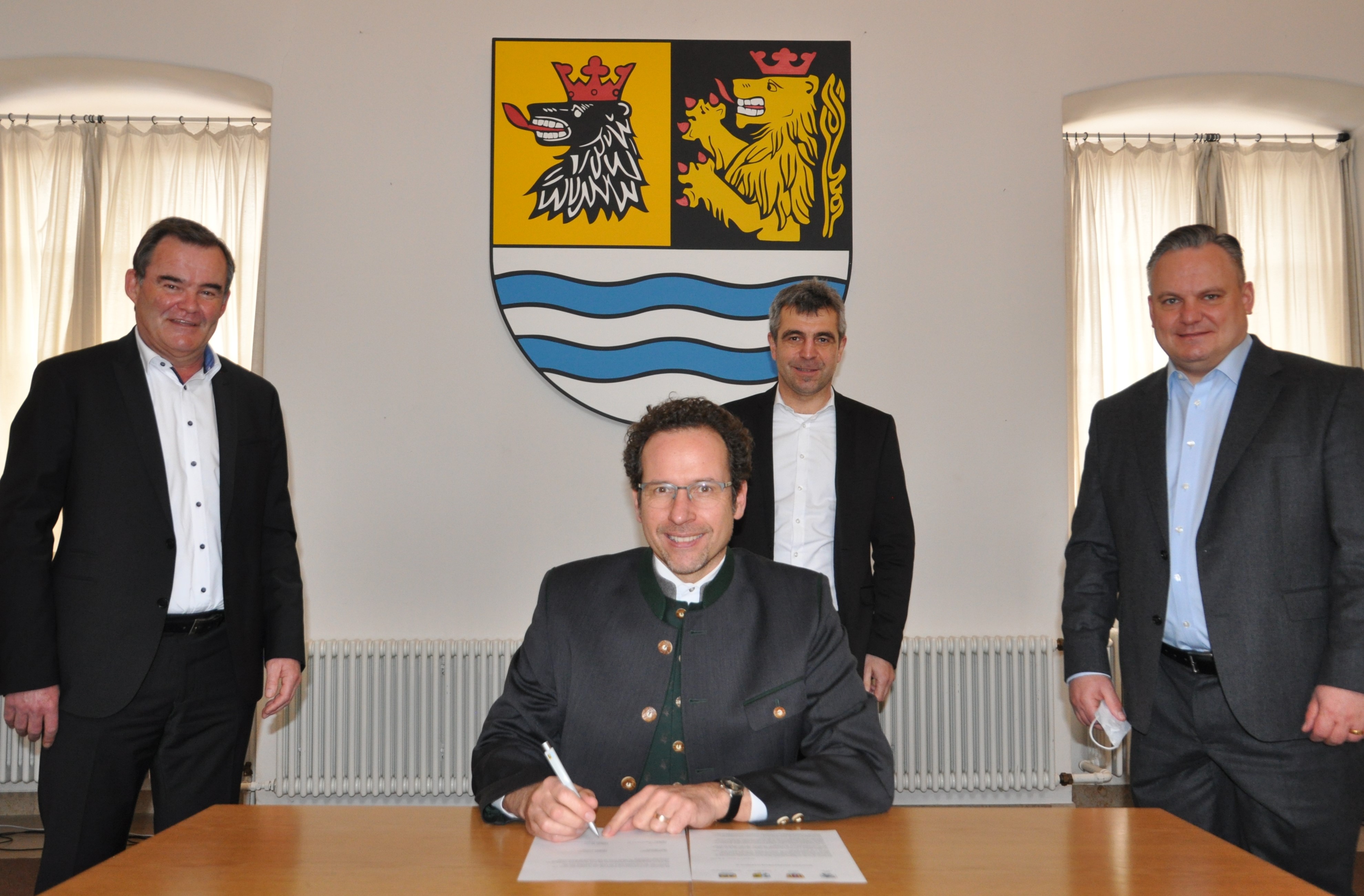 Peter von der Grün, Landrat des Landkreises Neuburg-Schrobenhausen, unterschreibt die gemeinsame Absichtserklärung der Region, mit dem er und seine Kollegen (stehend, von links) Albert Gürtner (Landkreis Pfaffenhofen a.d.Ilm), Alexander Anetsberger (Landkreis Eichstätt) und Dr. Christian Scharpf (Ingolstadt) den Antrag unterstützen.