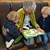 Oma liest zwei Jungs aus einem Buch vor