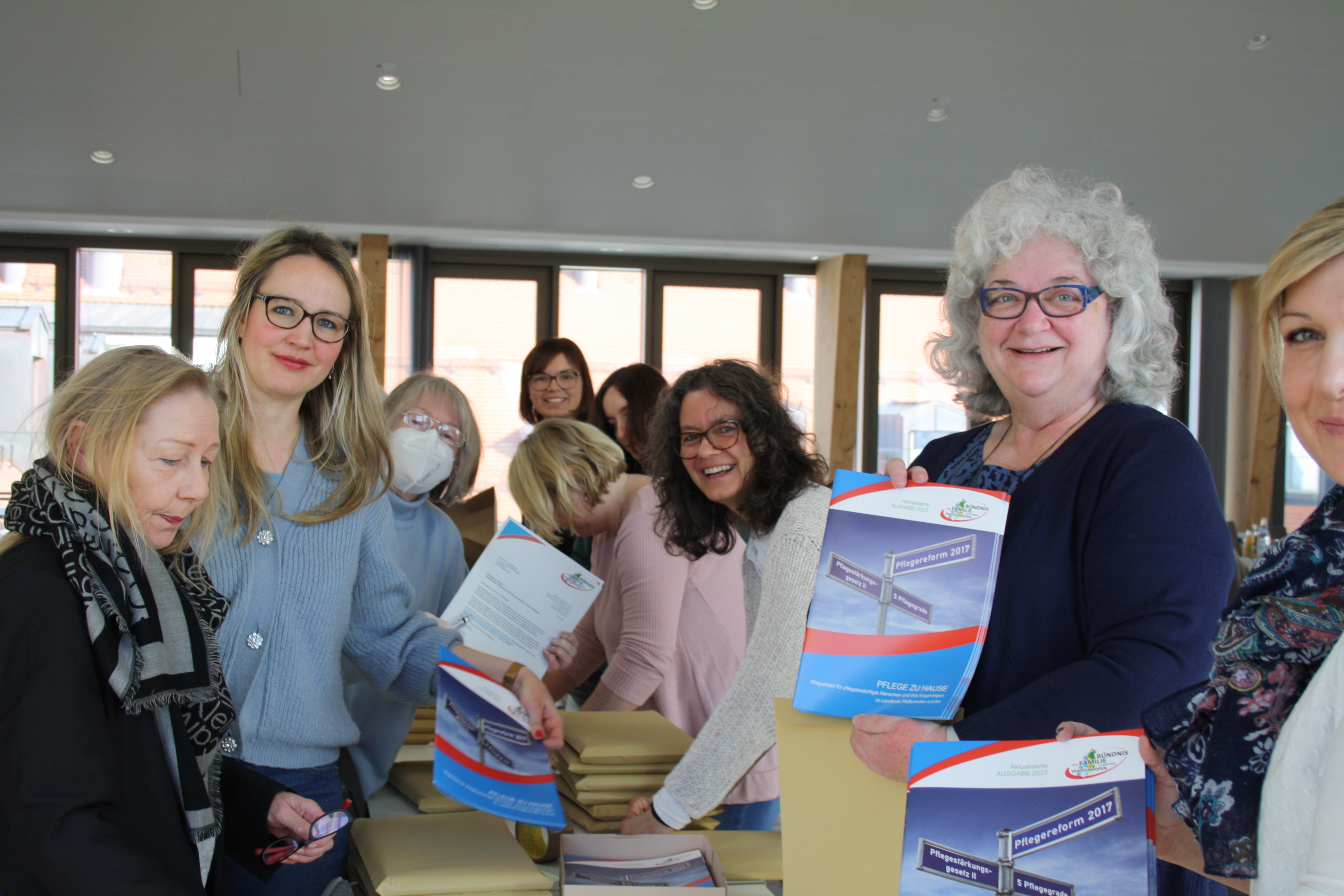Die Mitglieder der Arbeitsgruppe „Inklusion, Pflege, Behinderung“ des Bündnisses für Familie beim Verpacken der neuen Auflage der Pflegebroschüre. Menschen verpacken Broschüren