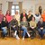 mehrere Personen stehen und sitzen in einer Gruppe nebeneinander