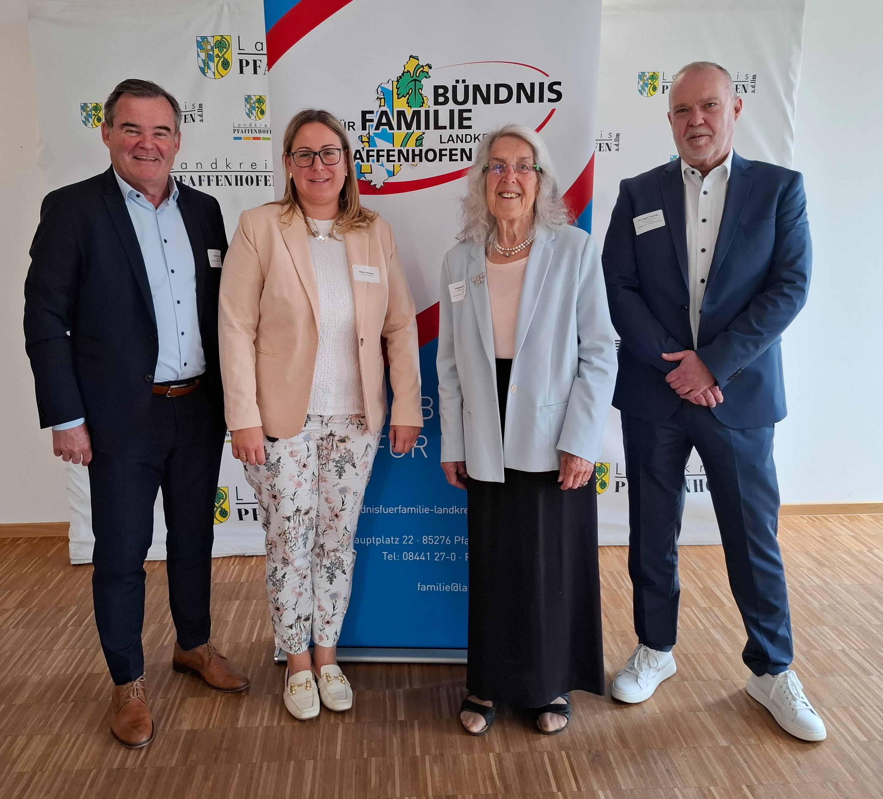 vier Personen stehen nebeneinander