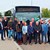 mehrere Personen stehen nebeneinander vor einem Bus