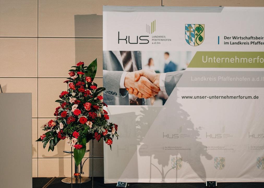 zwei Aufsteller und Blumen vor einer Wand