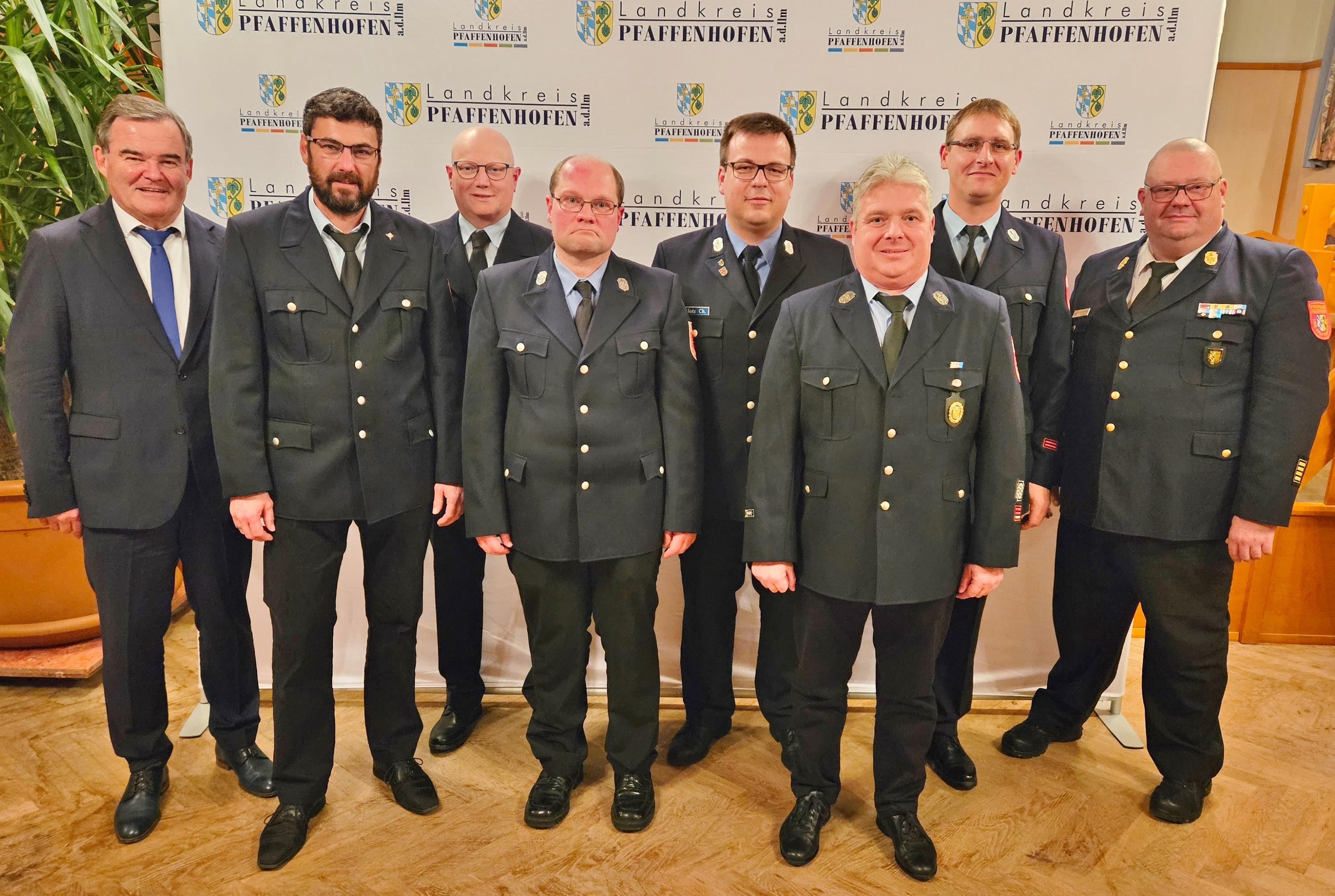 Die für 25 Jahre geehrten Feuerwehrmänner mit Landrat Albert Gürtner (li.) und Kreisbrandrat Christian Nitschke (re.) mehrere Personen stehen in einer Gruppe nebeneinander