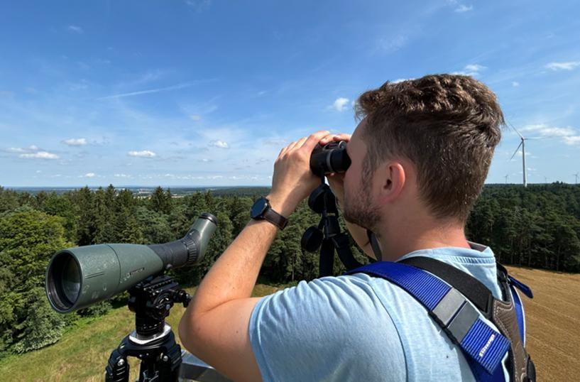 ein Mann schaut in ein Fernrohr
