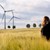 eine Person steht vor Windräder auf einem Feld