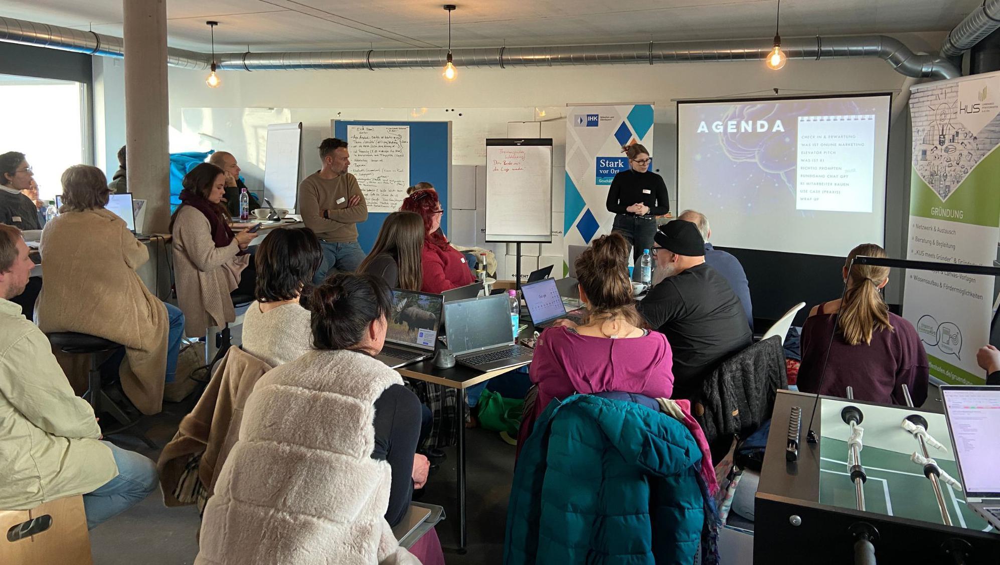 mehrere Personen sitzen bei einem Vortrag