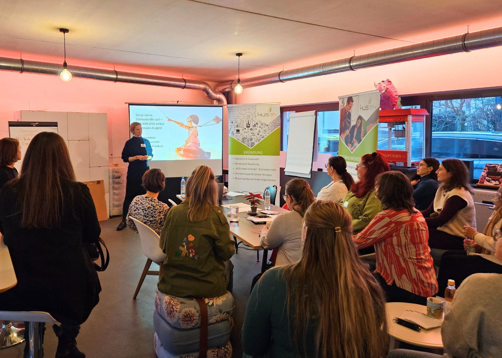 mehrere Personen sitzen bei einem Vortrag