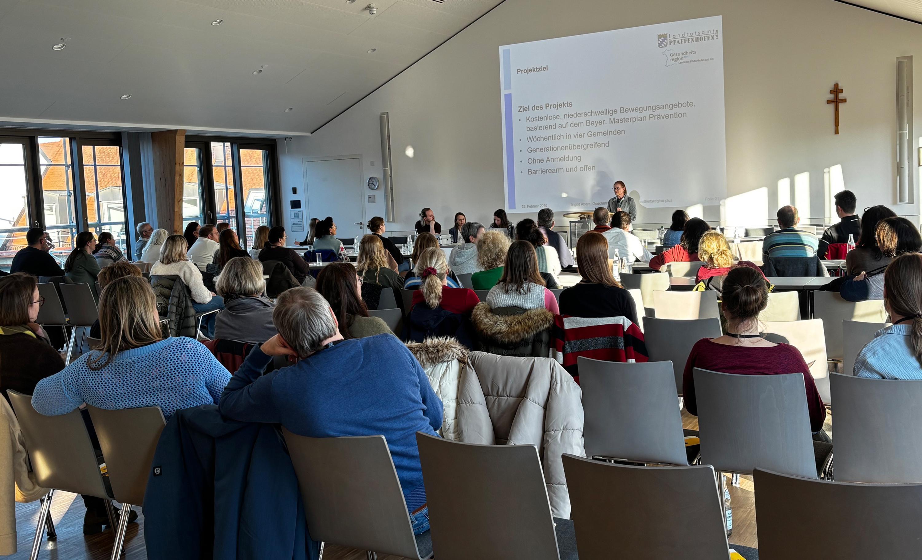 mehrere Personen sitzen bei einem Vortrag