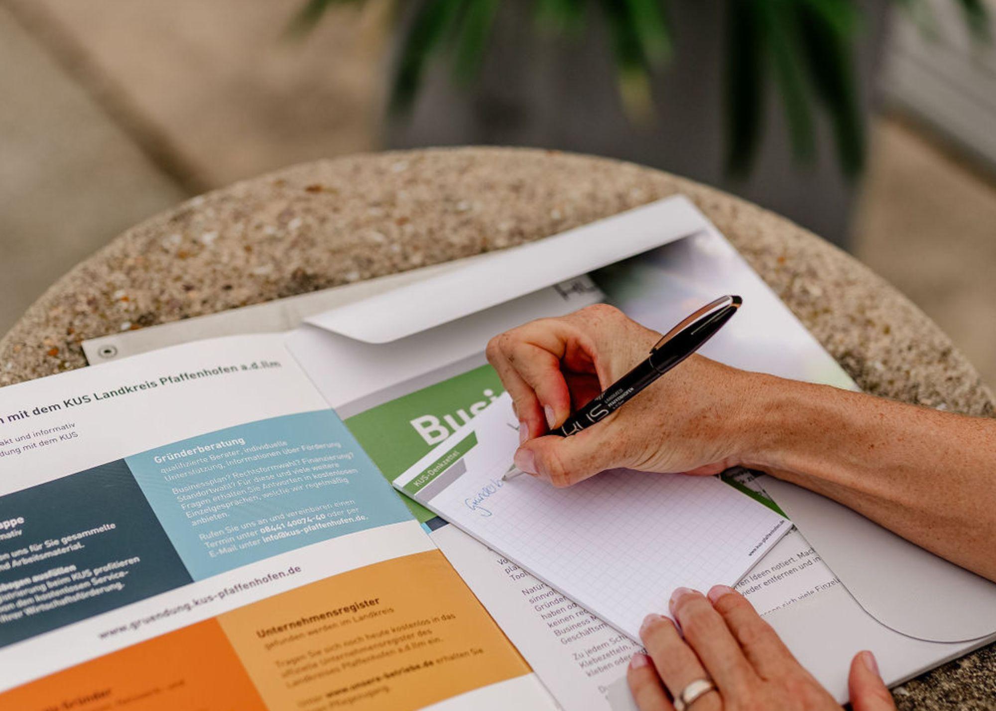 eine Hand schreibt auf einen Block