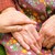 Frau hält Hand von Seniorin
