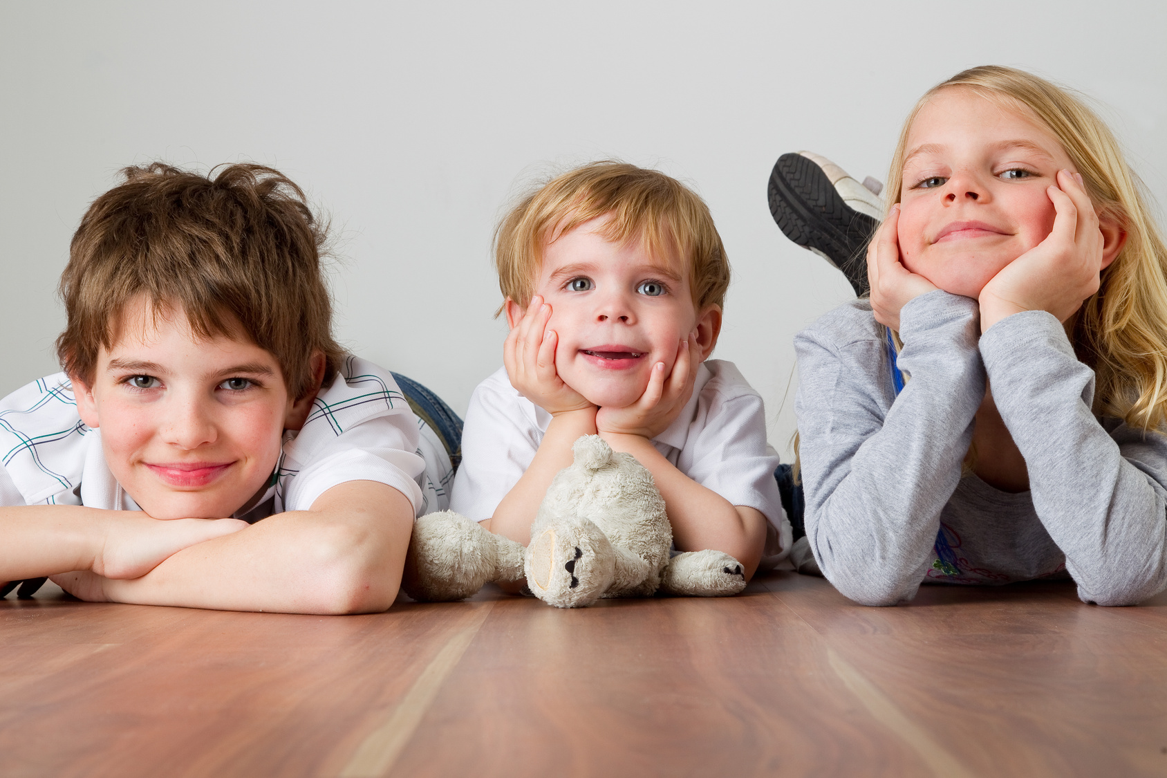 drei Kinder liegend am Boden